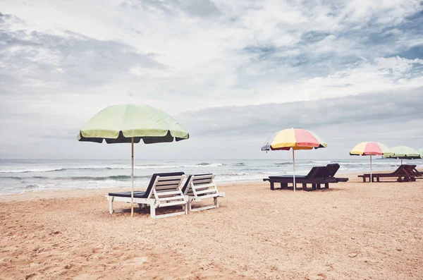 Camas de sol com guarda-sóis em uma praia vazia . — Fotografia de Stock