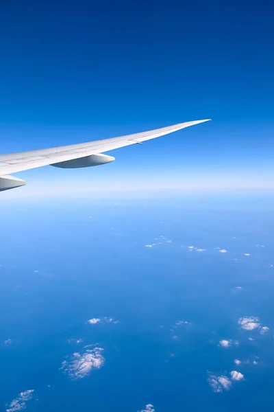 Ala de avião contra o céu azul visto de um avião . — Fotografia de Stock