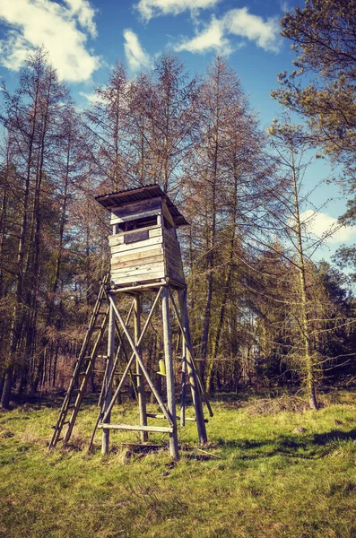 Old wooden elevated deer hunting blind, color toning applied.