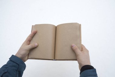 Bir adamın elinde kara karşı boş sayfaları olan bir kitap. Düşünen, boş alan.