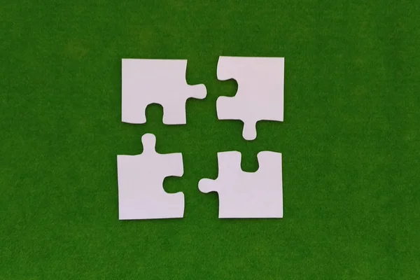 Four White Puzzles Green Background Parts Collecting — 스톡 사진