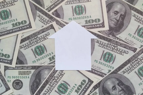 House made of white paper on the background of American dollar bills. Business, buying and selling real estate.