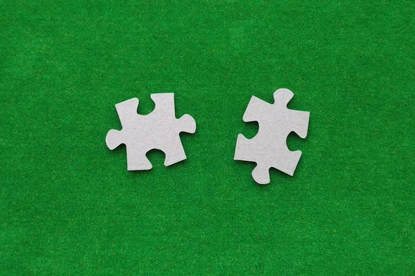 緑の背景に2枚の段ボールパズル — ストック写真