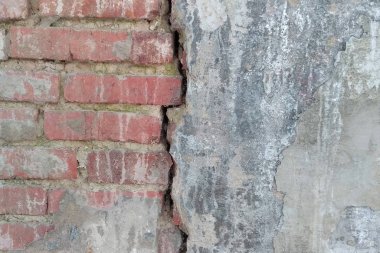 Yaşlanmaya tabi tuğla duvarın bir parçası, bir çatlakla ikiye bölünmüş.. 