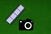 Fotoaparát, fotografický film na zeleném pozadí. Fotografie, dokumenty, kreativita.
