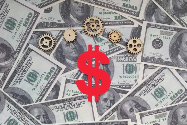Dollar sign, gears on the background of American dollar bills. Business. Financial cash.