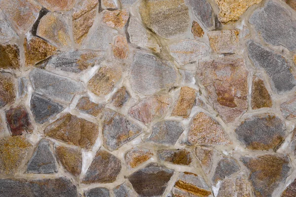 Duvarın dokusu granit taşlardan yapılmış. İnşaat, dekorasyon.