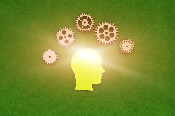 silhouette of a human head in yellow, gears on a green background. creative ideas.