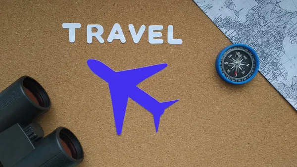 Airplane, binoculars, compass, map on a brown background. travel, tourism.