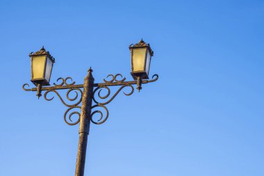Mavi gökyüzüne karşı çift sokak lambası. Yolun aydınlanması..
