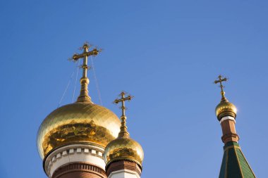 Mavi gökyüzüne karşı Ortodoks Kilisesi 'nin üç kubbesi. Dini bina. mimari.
