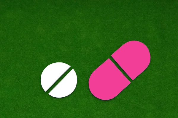 Twee Tabletten Van Witte Roze Kleur Een Groene Achtergrond Geneesmiddelen — Stockfoto