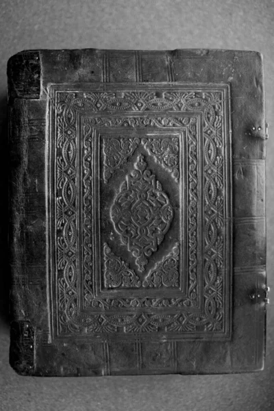 An old medieval religious book in leather binding in black and white.