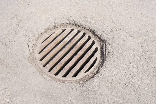Iron manhole on the road, storm drain. Underground communication..