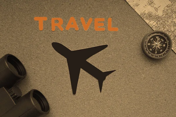 Plane, map, compass, binoculars on a brown background. the concept of travel and tourism.