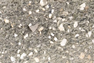 Duvarın dış kısmının dokusu çimento ve taş parçalarından yapılmıştır..