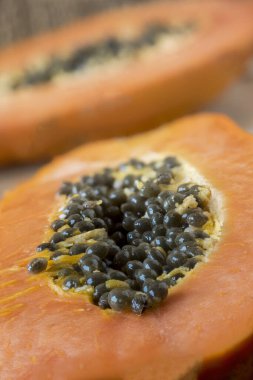 Olgun papaya meyvesi, tohumlarla yarıya bölünmüş.