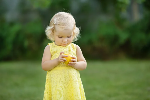 迷人的小女孩在公园里吃柠檬 — 图库照片