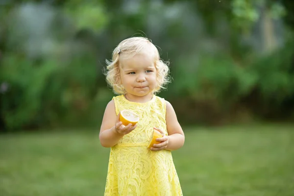 Charmante Petite Fille Mangeant Citron Dans Parc Image En Vente