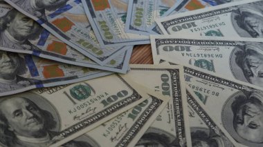 Koyu bir arka planda, bir cüzdanda, bir çekmecede birikmiş Amerikan doları.