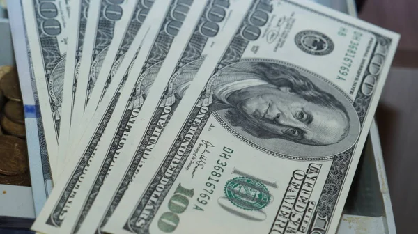 American dollars stacked on a dark background, in a wallet, in a cash drawer