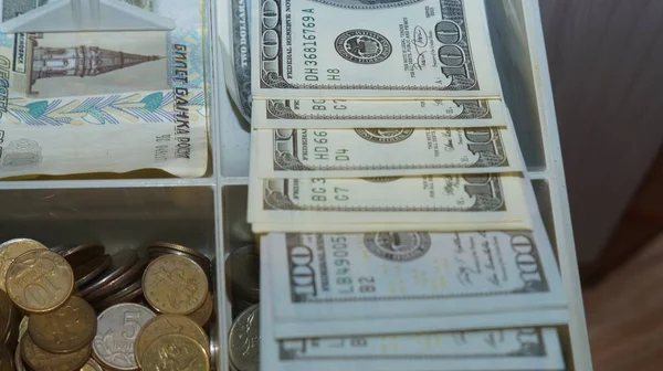 American dollars stacked on a dark background, in a wallet, in a cash drawer