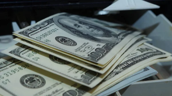 American dollars stacked on a dark background, in a wallet, in a cash drawer