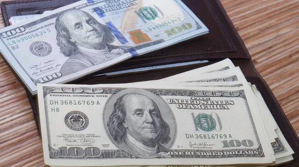 American dollars stacked on a dark background, in a wallet, in a cash drawer