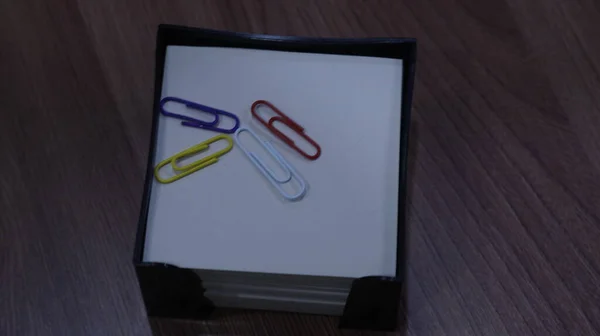 Office supplies: markers, paper clips, note paper, album on the background of the table
