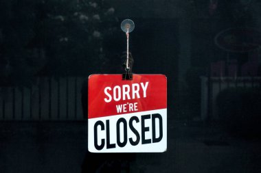 Closed sign in a shop window sorry we are closed clipart