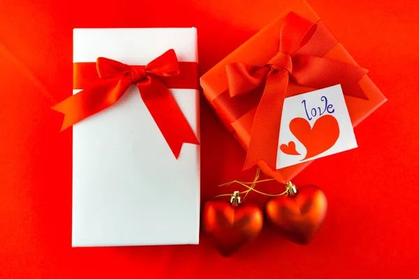 Valentýna dárkové krabičce s červenou mašlí na červeném pozadí obrázek z Va — Stock fotografie