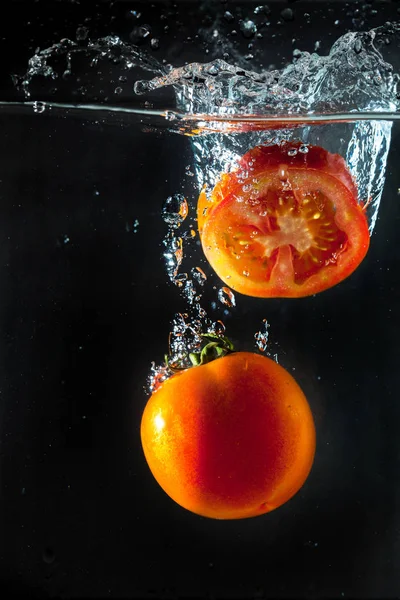 Pomodori spruzzando con in acqua — Foto Stock