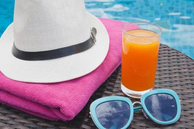 Yaz aylarında portakal suyu şapka ve güneş gözlüğü p Yüzme yakınındaki sakin ol