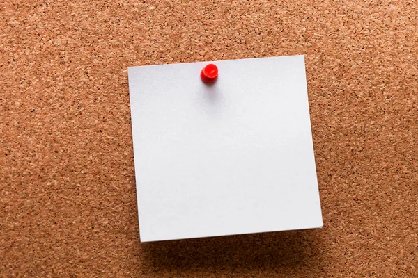 Papel blanco con clip rojo clavado en tablero de madera — Foto de Stock