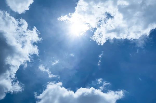 Zon op blauwe hemel met kleine wolk — Stockfoto