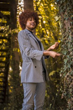 Parkta poz veren şık, genç, çekici Afrikalı Amerikalı kadın.