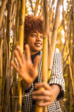 Bambuda saklanan genç ve çekici Afrikalı Amerikalı kadın.
