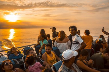 Roatan, Honduras - Ocak 2020: Karayip denizi üzerinde gün batımını izleyen turistler, Roatan, Honduras