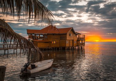 Roatan, Honduras - January 2020: Famous wooden bar over the Caribbean Sea on West End Beach on Roatan Island clipart