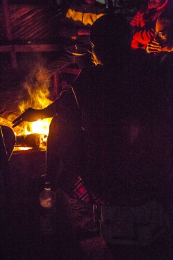 Masai Mara, Kenya - Ağustos 2018: insanlar gece ormanlarında şenlik ateşinin etrafında oturuyorlar