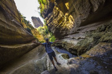 man walking through the canyons of Naivasha Hells Gate National park. Kenya