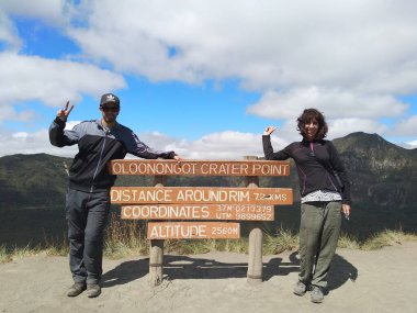 Kenya Naivasha Gölü yakınlarındaki Naivasha Hells Gate Ulusal Parkı 'ndaki Naivasha Oloongot Krateri' nin tahta tabelalarında poz veren çift.