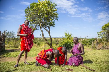 Masai Mara, Kenya - August 2018: A group of Masais making fire as before with wood