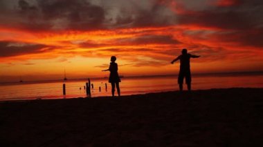 Çiftler sahilde eğleniyor ve gün batımının tadını çıkarıyorlar, Roatan, Honduras