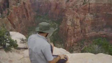 Utah, ABD 'deki Zion Ulusal Parkı' nda kayaların muhteşem manzarasının keyfini çıkaran bir adam. 