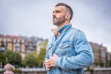 Kot ceketli çekici bir gencin portresi.