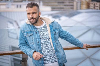 Kot ceketli çekici bir gencin portresi.