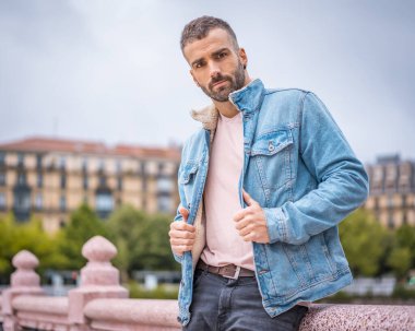 Kot ceketli çekici bir gencin portresi.