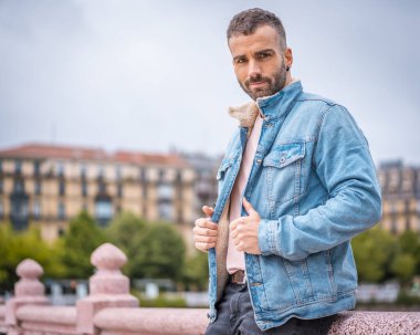 Kot ceketli çekici bir gencin portresi.