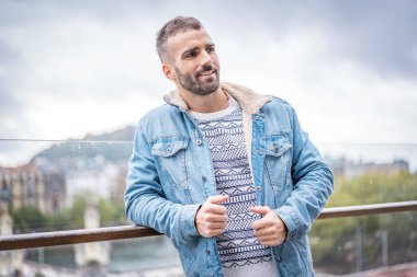 Kot ceketli çekici bir gencin portresi.